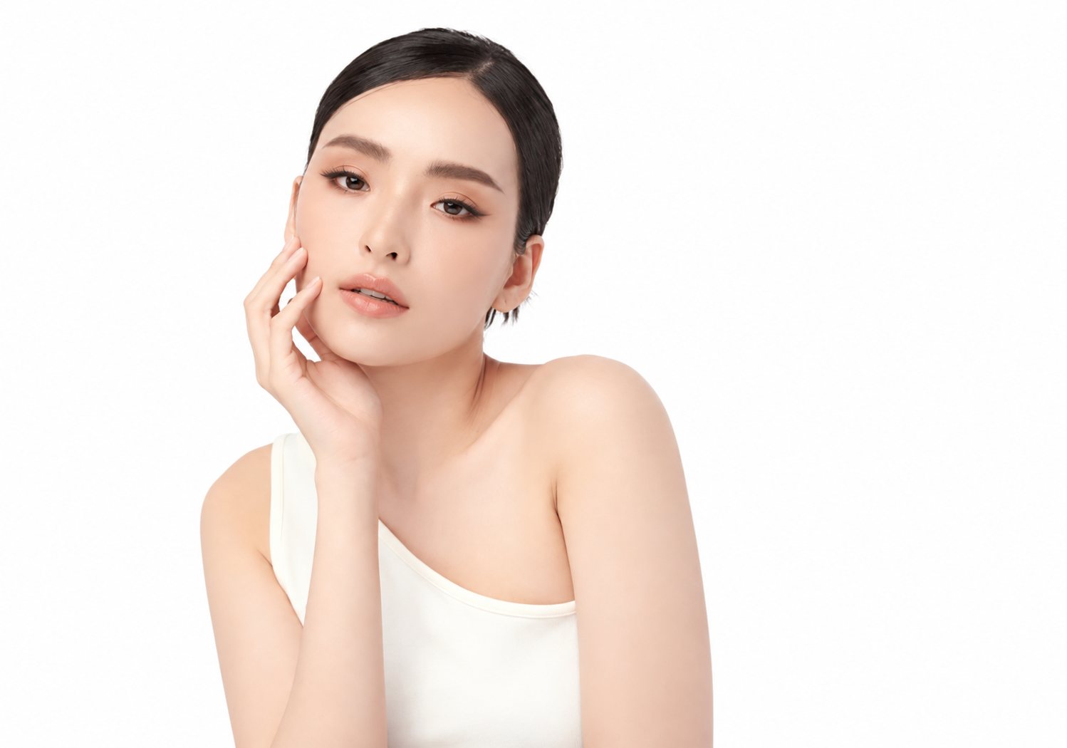 Woman with smooth, clear skin touching her cheek
